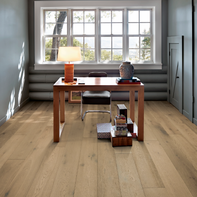 Light-stained hardwood flooring in a modern Ann Arbor home office. brown table, black office chair, with large white window 